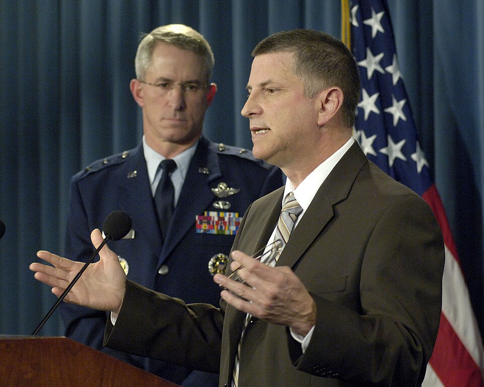 Principal Deputy Under Secretary of Defense for Personnel and Readiness Michael Dominguez (right) conducts a Pentagon press conference to announce a new program designed to recognize and compensate personnel for deployments or mobilizations extending beyond the established rotation policy parameters