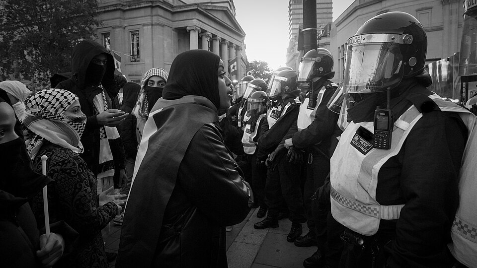 A Pro Palestine protester speaks with a PSU Police Officer at the northern edge of London's Trafalgar Square at a moment of tension in the crowd, following several arrests.  For notes regarding the tension between protesters and police late in the afternoon of 14 October and on why some protesters m