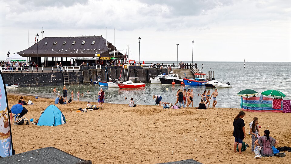 Beach holidaymakers and boat jetty in Viking Bay at Broadstairs in Kent, England.Mobile device view: Wikimedia (as at 2018) makes it difficult to view photos related to this image, so to see its most relevant allied group, click: Broadstairs.To see the subject galleries for this particular author's 