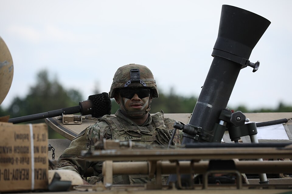 U.S. Army Pfc. Justice Tuia assigned to Headquarters and Headquarters Company, 1st Battalion, 9th Cavalry Regiment, 2nd Armored Brigade Combat Team, 1st Cavalry Division, supporting 4th Infantry Division, poses atop the M1064A3 mortar carrier vehicle on a range at Bemowo Piskie Training Area, June 1