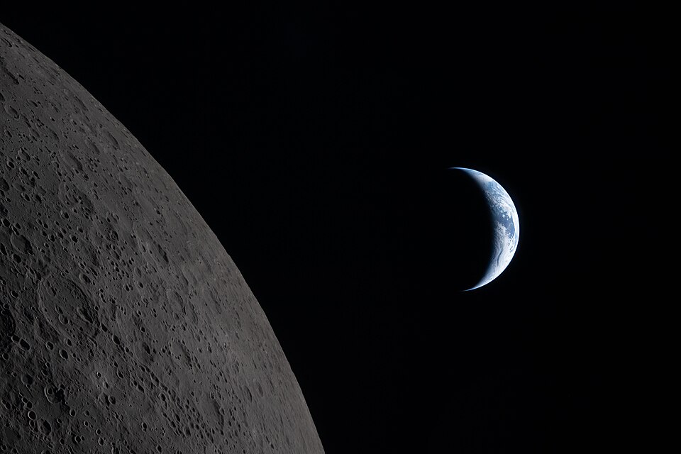 art002e009285 (April 6, 2026) – Our planet draws closer to passing behind the Moon in this image captured by the Artemis II crew during their lunar flyby, about six minutes before Earthset. Earth is in a crescent phase, with sunlight coming from the right. The dark portion of Earth is experiencing n