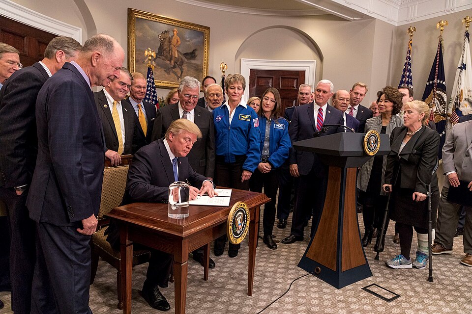 President Donald J. Trump, joined by Vice President Mike Pence, displays his signed Space Policy Directive 1 in the Roosevelt Room at the White House, Monday, December 11, 2017, in Washington, D.C. The directive will once again make a human return to the lunar surface part of U.S. space policy. Vice