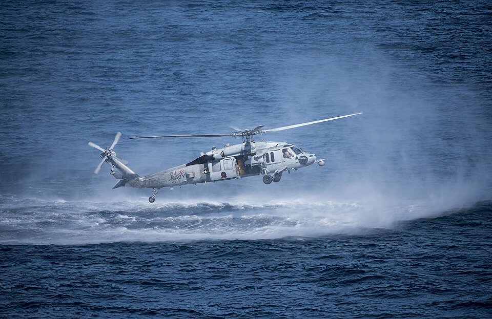 170810-N-FE442-125 ATLANTIC OCEAN (Aug. 10, 2017) An MH-60S Sea Hawk attached to the "Tridents" of Helicopter Sea Combat Squadron (HSC) 9 hovers at 10 feet above the water to simulate a rescue swimmer jump during an airpower demonstration rehearsal alongside the aircraft carrier USS George H.W. Bush