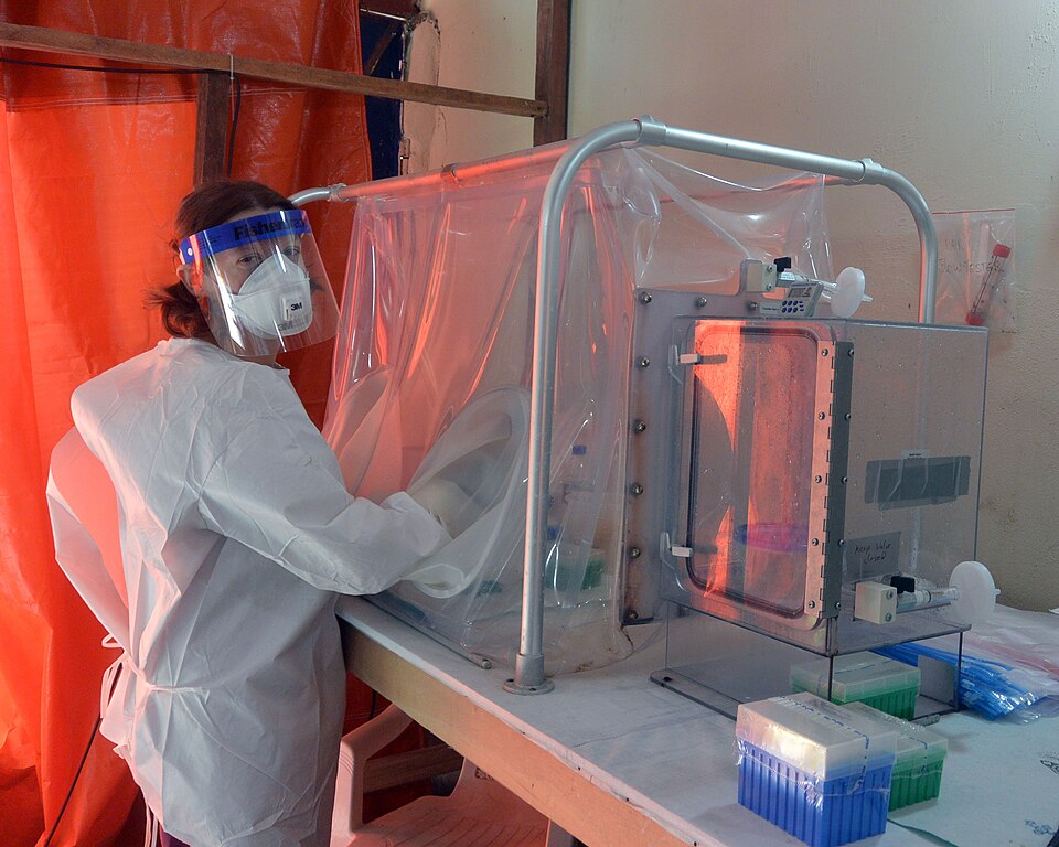 A NIAID researcher at a diagnostic laboratory in Monrovia during the 2014-15 outbreak uses a sealed glovebox to inactivate virus in patient blood samples prior to testing for Ebola.