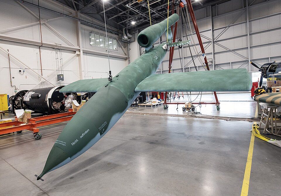 The V-1 (Vergeltungswaffe Eins, or Vengeance Weapon One), was the world's first operational cruise missile. This name was given to it by the Nazi Propaganda Ministry, but the original Air Ministry designation was Fi 103, after its airframe designer, the Fieseler company. Powered by a simple but nois