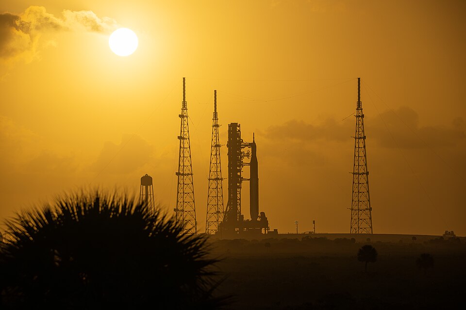 This image shows a sunset of NASA’s SLS (Space Launch System) and Orion spacecraft at NASA’s Kennedy Space Center. NASA's massive Crawler-Transporter, upgraded for the Artemis program, carried the powerful SLS rocket and Orion spacecraft on the Mobile Launcher from the Vehicle Assembly Building to L