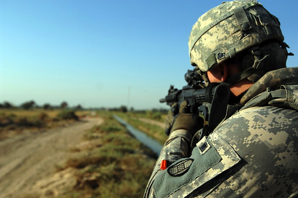 A U.S. Soldier, assigned to 1-150th Company, Bravo Troop, 3rd Platoon, pulls security as vehicles approach the closed off road in Jumabi Village, Yusifiyah, Iraq, Sept. 10, 2009. The U.S. Soldier helped pull security with members of the Iraqi army at a security checkpoint at the entrance of the vill