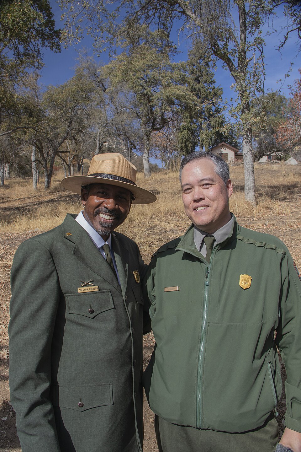 Two rangers in green uniforms, one wearing a tan flat hat, pose in front of a dried-out field.
Ranger Shelton Johnson of Yosemite National Park poses for a photo with Visual Information Specialist Tom Engberg of Charles Young Buffalo Soldiers National Monument.
Keywords: Charles Young; Buffalo Soldi