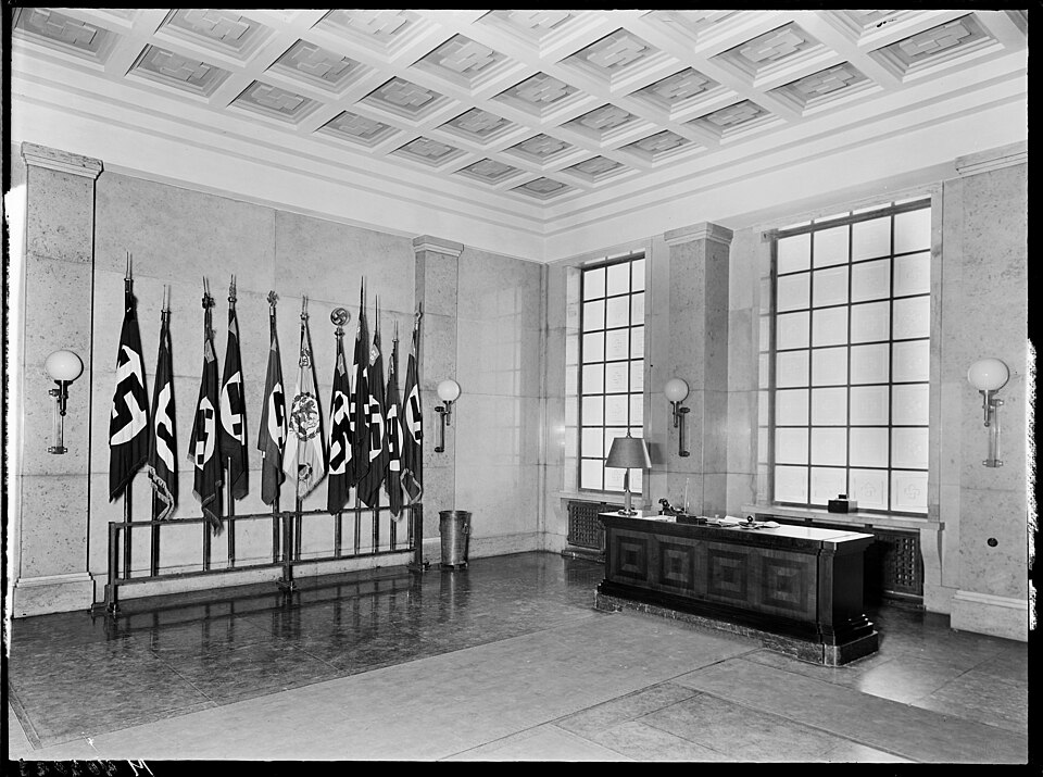 Fahnen-Halle ('Hall of Flags') in the reception/lobby on the ground floor of the Brown House, the headquarters of the Nazi Party (NSDAP) in Munich, Germany ca. 1932–1934. Important flags of the Munich NSDAP were kept here along with the old flags returned by the police. The battalion flags of the Mu