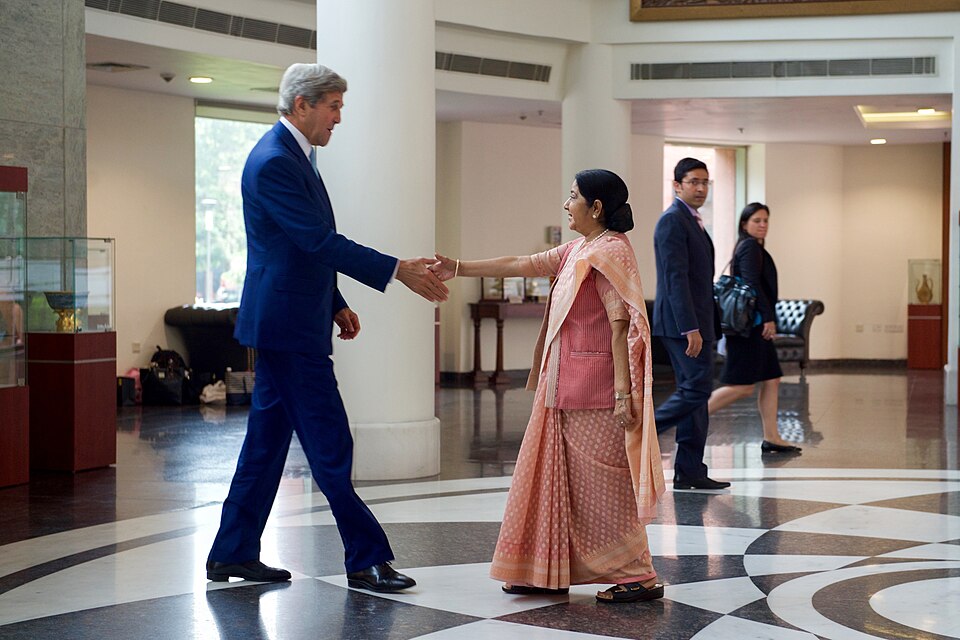 U.S. Secretary of State John Kerry approaches Indian Minister of External Affairs Shushma Swaraj on 