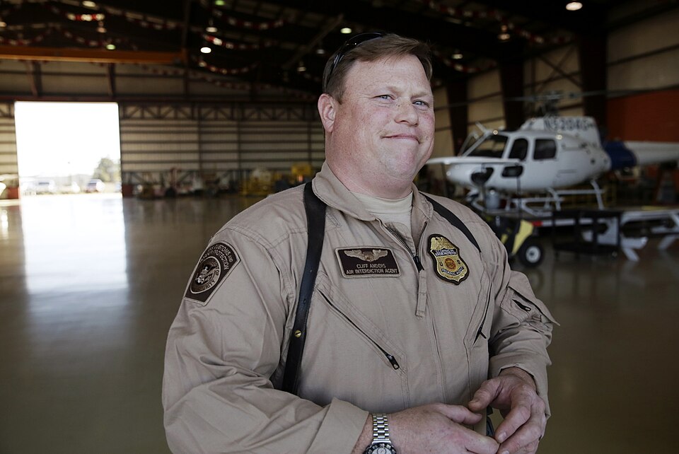 Air Interdiction Agent Cliff Anders looks out the hangar after conducting a pre-flight check of his AS350 A-Star helicopter prior to embarking on a flight at the U.S. Customs and Border Protection Houston Air Unit in Conroe, Texas, Jan. 30, 2017. Anders and a corps of CBP law enforcement agents and 