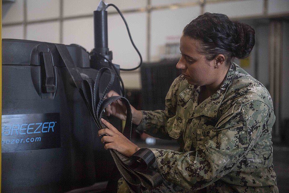 190702-N-EV253-0106 NAVAL STATION ROTA, Spain (July 2, 2019) Utilitiesman 2nd Class Briana Phillips, assigned to Naval Mobile Construction Battalion (NMCB) 133 and deployed from Task Force 68, secures water purification equipment aboard the Spearhead-class expeditionary fast transport ship USNS Cars