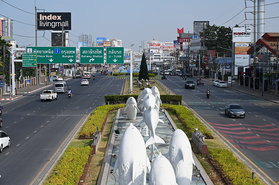 This photo features a busy city street with various vehicles, including cars, motorcycles, and a truck. There are several cars and motorcycles driving down the street, and a truck is visible in the background. A person can be seen walking on the sidewalk, and another person is riding a motorcycle.
I