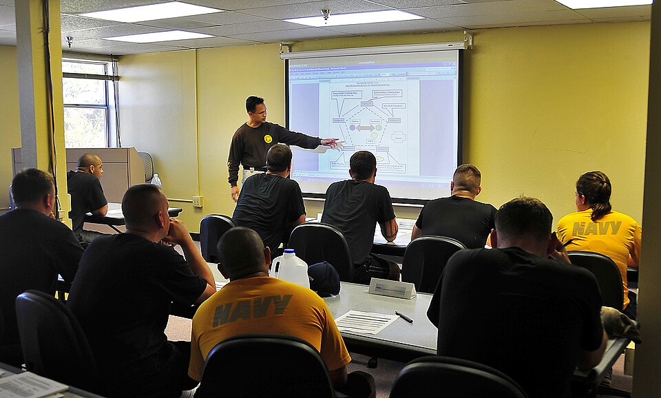 Law enforcement personnel study tactical operation maneuvers in a classroom session during the Navy Security Forces Training Course. The course is a pilot program being taught at Naval Air Station North Island. The nine-week program teaches cooperation between civilian and military police forces.