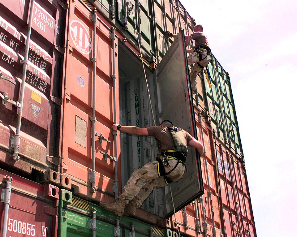 Boarding team members from the USS Lake Champlain (CG 57) rappel down cargo containers stacked on the deck of the merchant ship Puerto Cortes while it is stopped on a routine inspection in the Persian Gulf on May 15, 2000. The Lake Champlain is conducting Military Interdiction Operations in the Pers