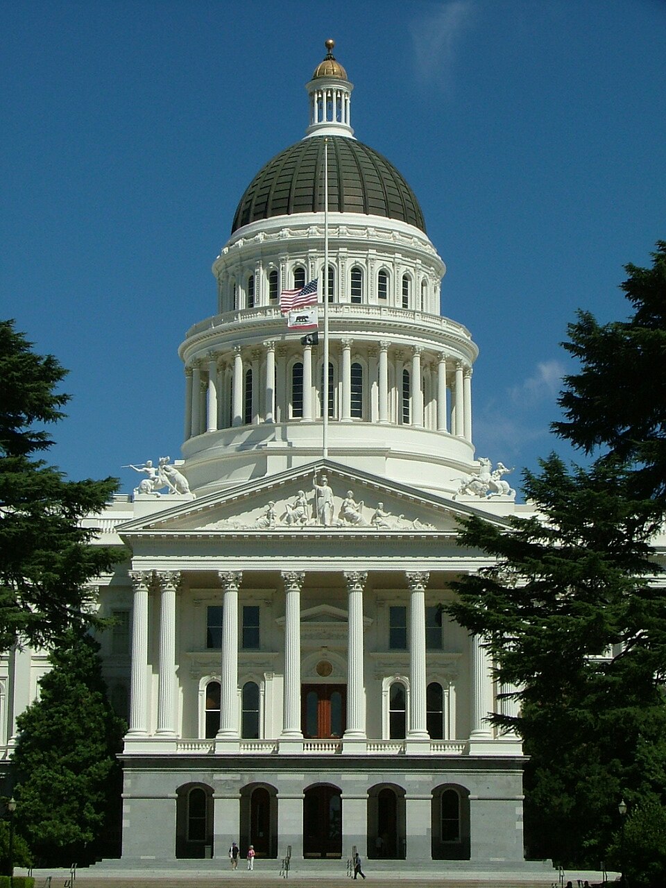 State capitol building on a clear day, surrounded by trees. Photo taken in July 2009 to commemorate a fallen firefighter.