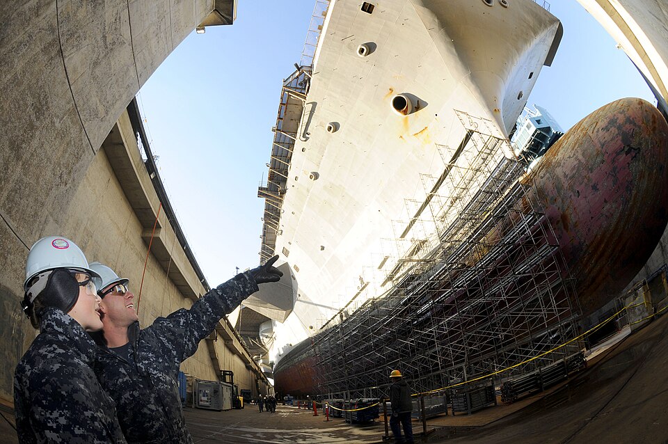 NAVAL BASE KITSAP-BREMERTON, Wash. (Feb. 3, 2012) Aviation Boatswain's Mates (Handling) Airmen, Brianna Luttrell, from Bonanza, Ore., and Matthew Page, from Boston, view the aircraft carrier USS Ronald Reagan (CVN 76) from the ground level of its dry dock. Ronald Reagan is in Bremerton, Wash., for a