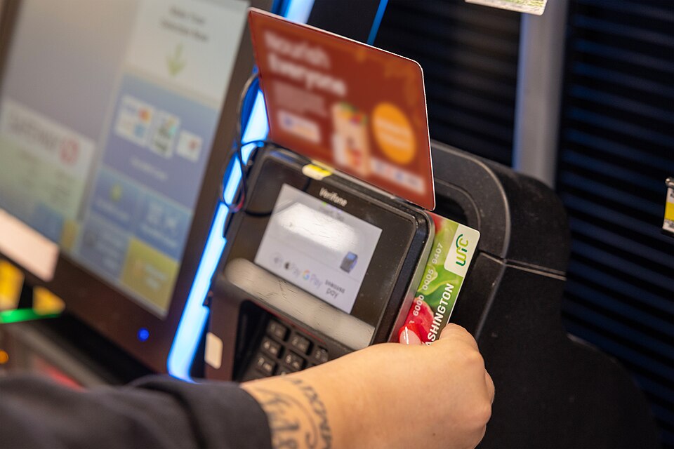WIC shopper slides EBT card to pay for WIC foods at self-checkout lane in a grocery store in Seattle, WA. (September 2024).