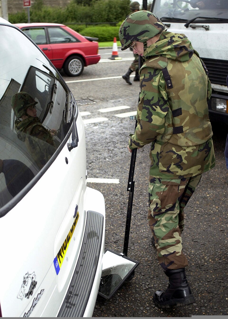 With stepped up security, a 48th Security ForceÕs member inspects the undercarriage of a vehicle before granting it permission to enter RAF Lakenheath, UK. Shortly after 8 AM (EST) on September 11, 2001 in an attempt to frighten the American people, terrorist mounted attacks on the World Trade Cente
