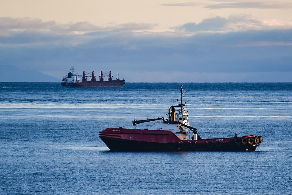 Ship escort, rescue and oil response oceangoing tugboat, TANERLIQ (TAN'ERLIQ, Tan'erliq) - IMO 9178381, off Port Angeles, Washington USA on November 19, 2021. General self-loading cargo ship in background is unknown. TANERLIQ is owned and operated in the Pacific Northwest by Crowley Ship Assist and 