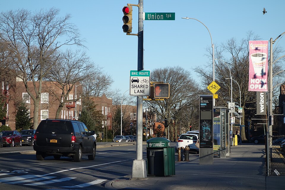 A sign for the shared bicycle lane on northbound Main Street, at the northeast corner of Main Street and Union Turnpike in Kew Gardens Hills, Queens.