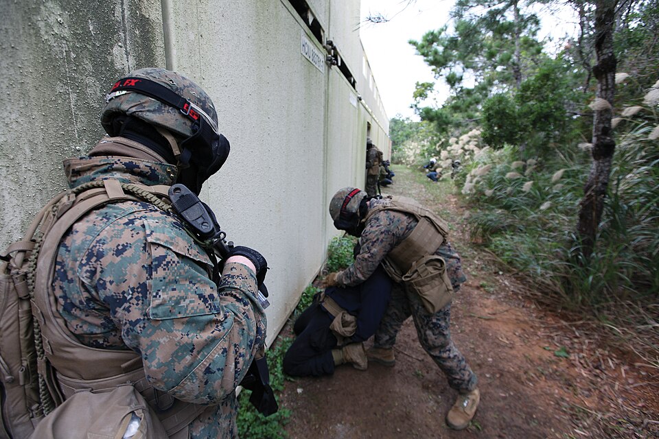 A Marine with 3rd LE Bn. searches and secures a simulated enemy combatant while another provides security Jan. 16 during MOUT training at Combat Town in the Central Training Area. Marines with the battalion perfected a variety of skill-sets from patrolling to room clearing in preparation for future 